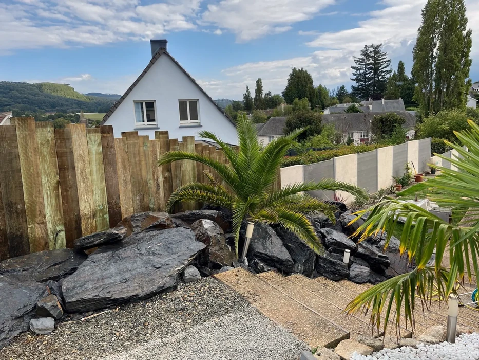 Ce beau jardin boisé de l'arrière-cour dispose d'une pelouse sans entretien, faite d'herbe artificielle réaliste, une tendance paysagée énorme pour les petits espaces