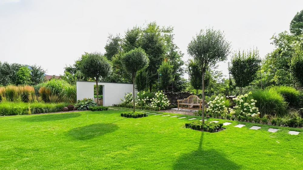 Un jardin paysager dans le désert en Arizona avec de l'herbe artificielle et un pont de piscine carrelé de travertin