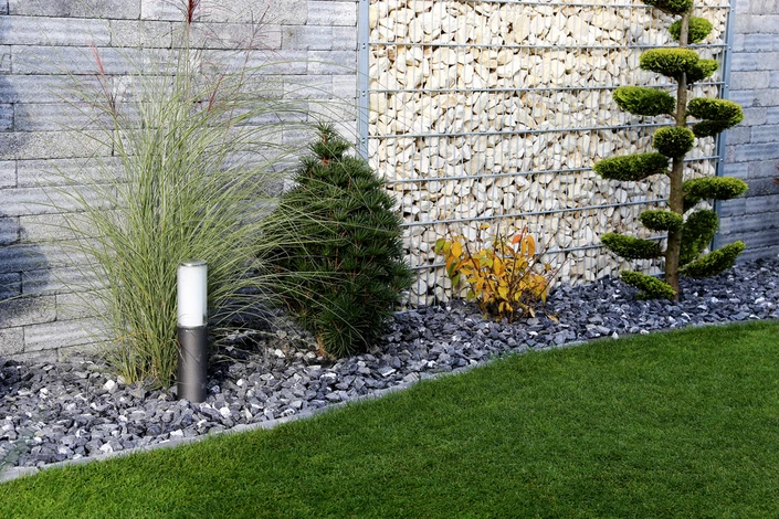 Terrasse extérieure aménagée avec salon de jardin en résine tressée marron, table ronde et chaises rembourrées